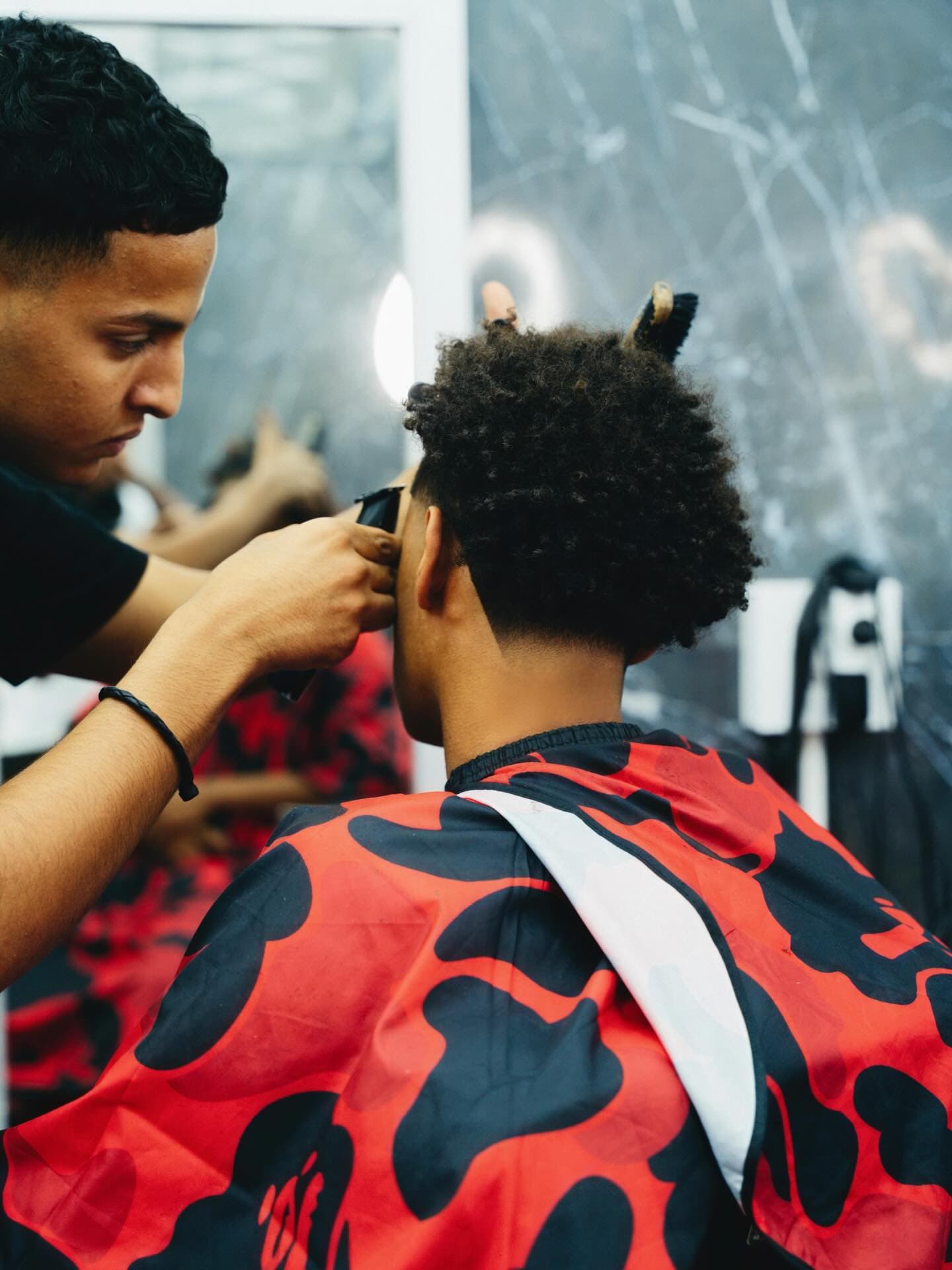 Brahim at work on a client's haircut at El Salon de la Fama